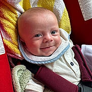Alessio a rejoint le concours — aidez-le/la à gagner de superbes lots ! baby, smiling, car_seat, blanket, towel, red, yellow, white, straps, clothing, infant, cute, face, head, child, sitting, portrait, happy, indoors, closeup