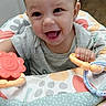 Kaliana is registered to the contest to win money with this photo: baby, child, infant, smiling, laughing, portrait, face, indoor, activity_seat, toy, teething_toy, colorful, gray_shirt, brown_hair, sitting, nursery, playtime, happy, closeup, photography