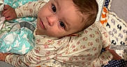 Kaliana is registered to the contest to win money with this photo: baby, infant, child, portrait, face, eyes, looking_up, smiling, indoors, nursery, crib, blanket, diaper, stuffed_animal, floral, patterned, pajamas, seated, cozy, photography