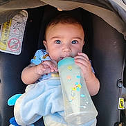 Alezyo participe au concours pour gagner de l'argent avec cette photo : baby, bottle, car_seat, blanket, child, cute, feeding, infant, seatbelt, toy, blue, comfort, clothing, sitting, face, portrait, young_child, indoors, security, happy