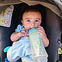 baby, bottle, car_seat, blanket, child, cute, feeding, infant, seatbelt, toy, blue, comfort, clothing, sitting, face, portrait, young_child, indoors, security, happy