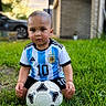 toddler, child, soccer_ball, grass, outdoor, sportswear, jersey, argentina, number_10, shorts, greenery, portrait, young_child, playing, ball, summer, daylight, focused, cute, sport