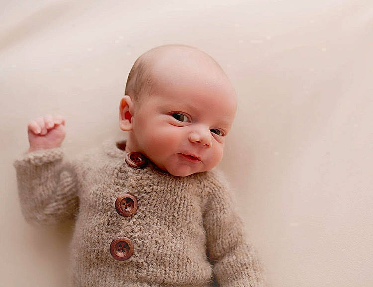 Johnnie is registered to the contest to win money with this photo: baby, cheek, child, eye, face, fur, head, lip, nose, outerwear, person, pink, skin, sleeve, toddler, toy, wool