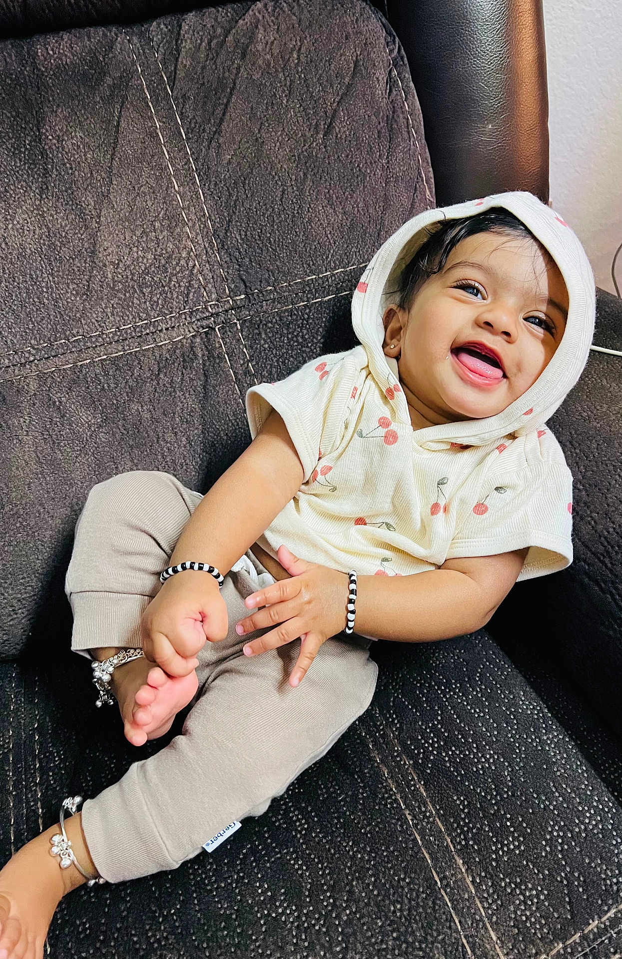 Arha joined the competition — help win amazing prizes! baby, child, smile, hoodie, cherry_print, bracelet, anklet, couch, sitting, happy, cute, clothing, person, indoors, portrait, infant, skin, hand, foot, jewelry