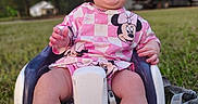 Amara is registered to the contest to win money with this photo: baby, child, infant, sitting, outdoor, grass, baby_seat, pink_clothing, minnie_mouse, smiling, happy, cute, nature, trees, daylight, playtime, seat, feet, portrait, person