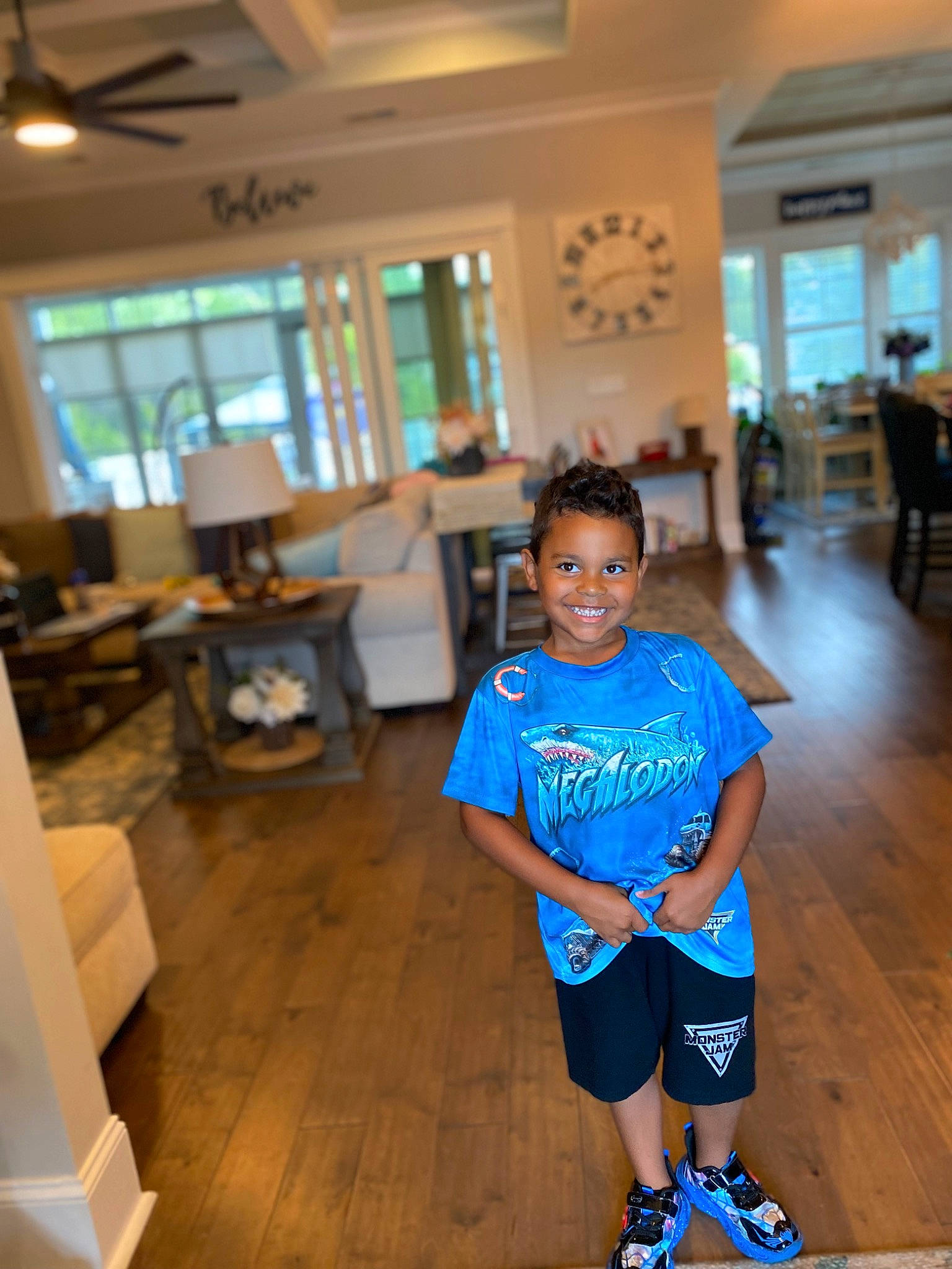 James is registered to the contest to win money with this photo: chair, child, electric_blue, event, floor, flooring, fun, happy, hardwood, human_leg, joy, leisure, person, recreation, room, shorts, smile, sportswear, t_shirt, thigh