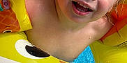 Braylon is registered to the contest to win money with this photo: child, toddler, pool, water, floaties, inflatable, yellow, swimming, summer, happy, wet, face, blue_eyes, smile, fun, outdoor, play, toy, closeup, joy