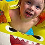 child, toddler, pool, water, floaties, inflatable, yellow, swimming, summer, happy, wet, face, blue_eyes, smile, fun, outdoor, play, toy, closeup, joy