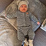 Noah participe au concours pour gagner de l'argent avec cette photo : baby, infant, child, hat, clothing, sneakers, blanket, couch, floor, person, footwear, soft_texture, indoor, laying_down, cute, cozy, warm, comfortable, small, headwear
