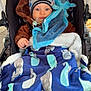 Noah participe au concours pour gagner de l'argent avec cette photo : baby, stroller, hat, blanket, blue, octopus, whale_pattern, pacifier, cozy, child, cute, warm_clothing, outdoor, bundle, infant, plush_toy, face, person, winter, soft