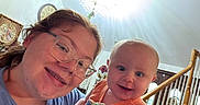 Liam is registered to the contest to win money with this photo: baby, child, person, smile, indoor, staircase, glasses, chandelier, holding, happy, face, portrait, casual, home, wood, light, clothing, young_adult, baby_toy, family