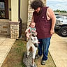 Liam is registered to the contest to win money with this photo: baby, man, statue, horse, outdoor, building, stone_wall, sidewalk, grass, car, smile, person, child, curly_hair, beard, casual_clothing, daytime, parking_lot, footwear, portrait