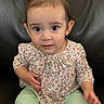 toddler, child, baby, sitting, pink_bow, floral_top, mint_green_pants, couch, leather, curious, face, eyes, hands, indoor, portrait, cute, young_child, casual_clothing, small_hands, infant