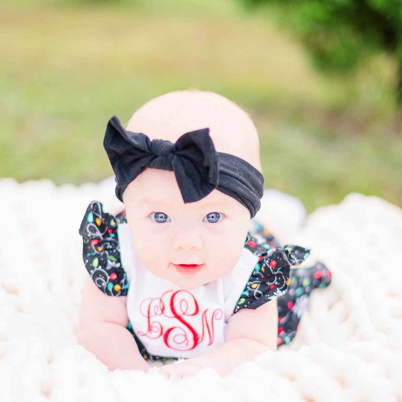 Lillie is registered to the contest to win money with this photo: baby, baby_products, baby_toddler_clothing, beanie, cap, carmine, child, doll, fashion_accessory, fun, fur, grass, happy, leisure, pattern, people_in_nature, recreation, sitting, toddler, toy