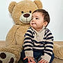 baby, toddler, teddy_bear, plush_toy, child, portrait, indoor, cute, striped_sweater, jeans, bare_feet, smile, soft_toy, wood_floor, sitting, face, fur, white_wall, cozy, playful