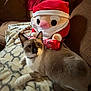 Smokey is registered to the contest to win money with this photo: cat, plush_toy, santa_claus, candy_cane, blanket, couch, indoor, feline, pet, relaxing, holiday, decor, patterned_blanket, brown_couch, toy, soft_toy, cute, domestic_animal, collar, furry