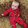 baby, child, infant, smiling, portrait, sitting, hay, hay_bale, farm, outdoor, red_pajamas, cartoon_print, clothing, blue_eyes, blond_hair, hands, feet, rustic, agriculture, photography