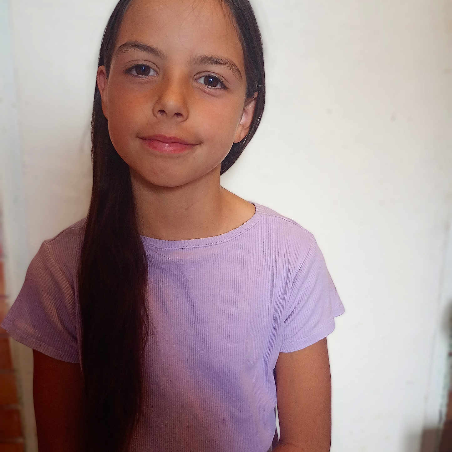 Myha a rejoint le concours — aidez-le/la à gagner de superbes lots ! background_blur, calm, casual_clothing, child, face, girl, human, indoor, long_hair, looking_at_camera, natural_light, person, portrait, purple_shirt, relaxed, short_sleeves, skin, smile, standing, young