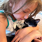 Rocketship is registered to the contest to win money with this photo: child, cat, black_and_white_cat, indoor, human, pet, affection, hugging, close_up, gentle, love, caring, cute, young, tender, face, arm, hair, white_shirt, natural_light