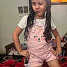 bed, blanket, child, colorful_screen, confident, furniture, girl, home, indoor, long_hair, pink_overalls, playful, posing, remote_control, room, smile, television, vent, wall, white_shirt
