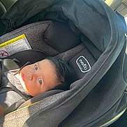 Uriel joined the competition — help win amazing prizes! baby, car_seat, infant, child, seatbelt, car_interior, window, sunlight, black, clothing, face, head, person, transportation, vehicle, seat, safety, portrait, young_child, infant_carrier