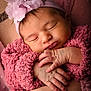 newborn, baby, sleeping, pink, headband, flower, blanket, hands, arms, closeup, soft, cozy, infant, person, skin, texture, peaceful, portrait, child, resting