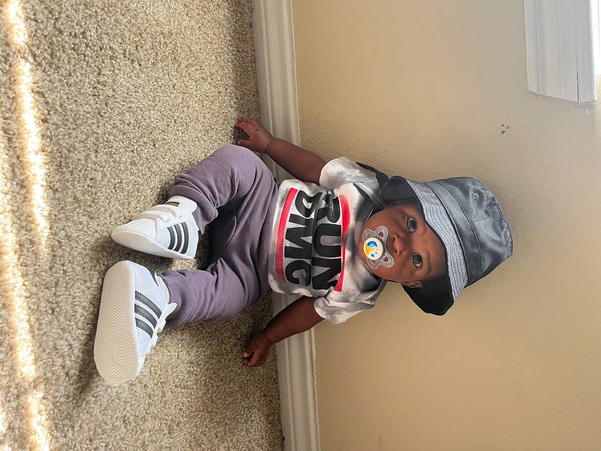 Ellis is registered to the contest to win money with this photo: baseball_cap, carmine, concrete, elbow, eyewear, flooring, hat, headwear, human_leg, knee, person, personal_protective_equipment, sitting, sleeve, sneakers, sportswear, sunglasses, t_shirt, thigh, walking_shoe