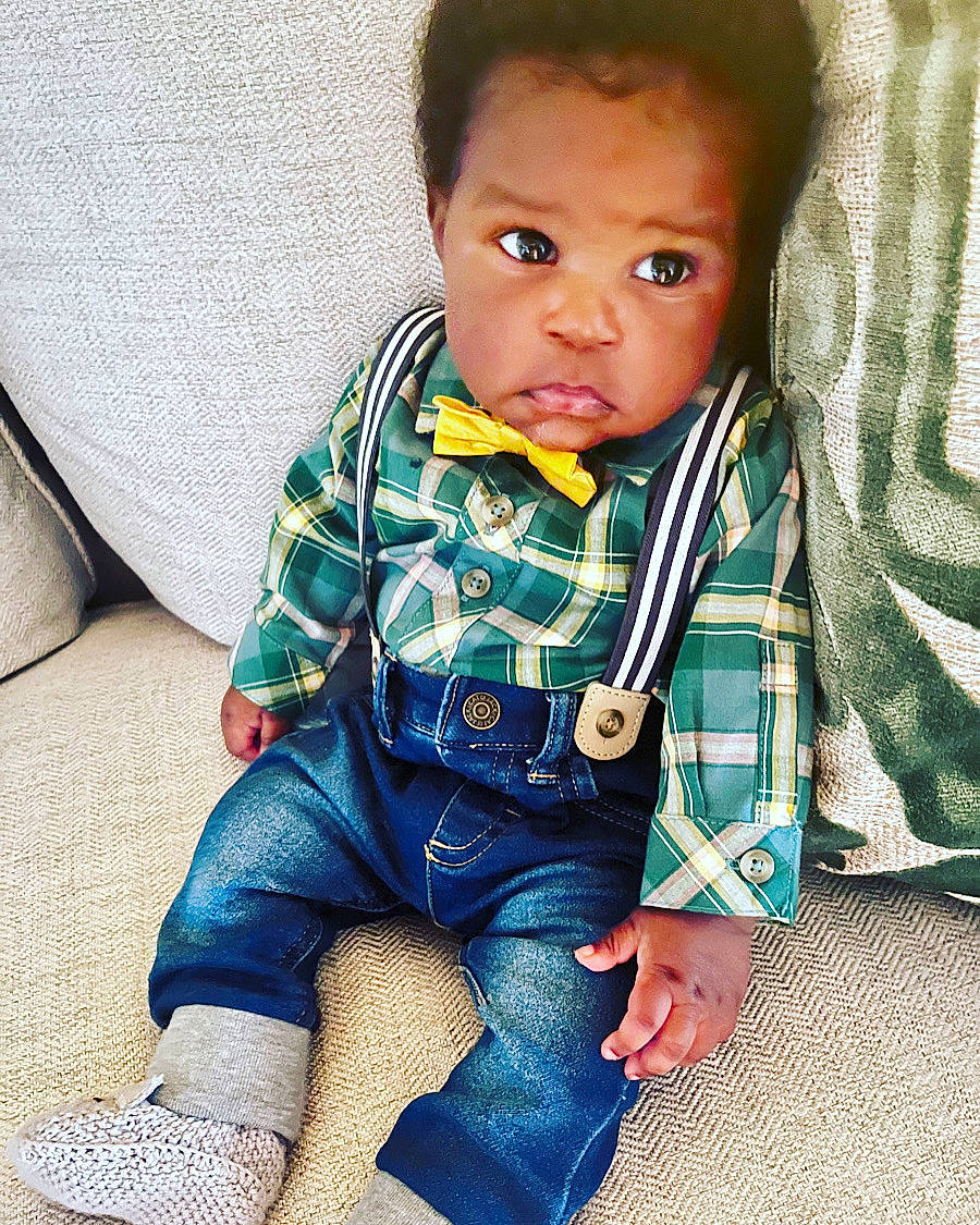 Ellis is registered to the contest to win money with this photo: baby, baby_toddler_clothing, cheek, child, collar, comfort, denim, electric_blue, flooring, happy, human_leg, linens, pattern, person, plaid, sitting, skin, sleeve, sock, t_shirt