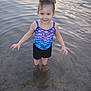 Ellianna is registered to the contest to win money with this photo: barefoot, casual, child, curly_hair, happy, nature, necklaces, outdoor, playful, reflection, ripples, shorts, smiling, standing, summer, sunset_reflection, swimsuit, water, water_surface, young_girl