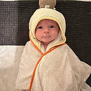 Anaya participe au concours pour gagner de l'argent avec cette photo : baby, infant, towel, hooded_towel, plush_toy, face, eyes, smile, floor_tiles, texture, orange_trim, blanket, cute, child, indoors, soft, wrapped, portrait, looking_at_camera, laying_down