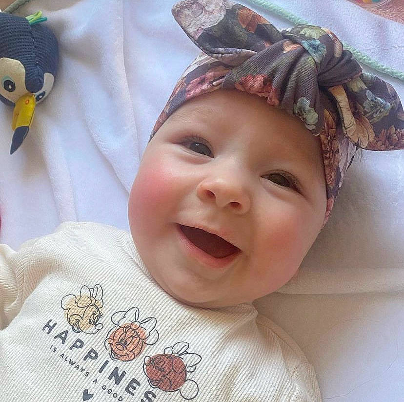 Maria a rejoint le concours — aidez-le/la à gagner de superbes lots ! baby, baby_laughing, baby_toddler_clothing, cap, cheek, child, chin, facial_expression, happy, head, headgear, headwear, neck, nose, organ, person, pink, skin, sleeve, smile