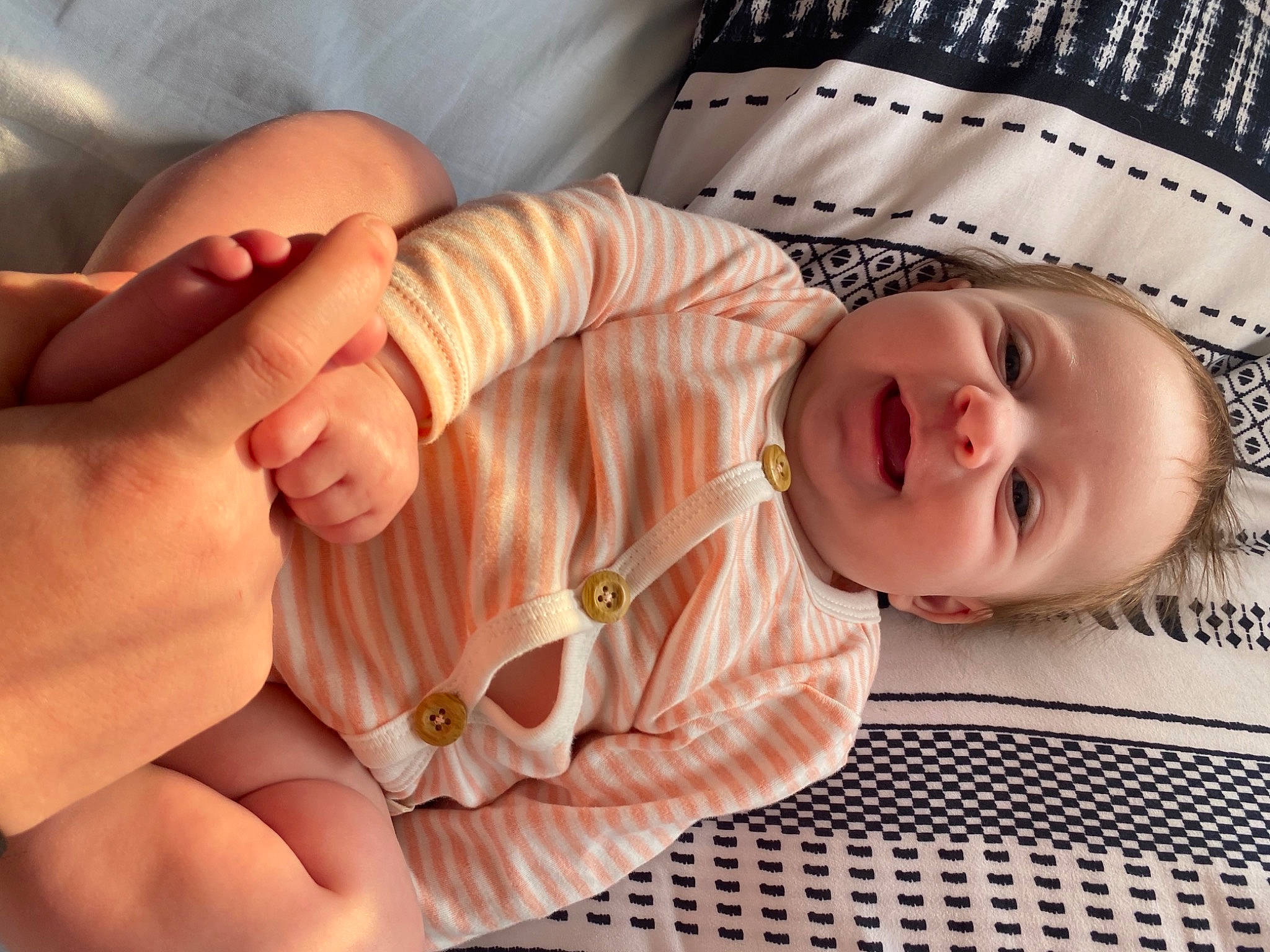 Mabel is registered to the contest to win money with this photo: baby, baby_toddler_clothing, cheek, comfort, eye, facial_expression, finger, gesture, hand, head, human_body, mouth, organ, person, pink, product, skin, sleeve, smile, thumb