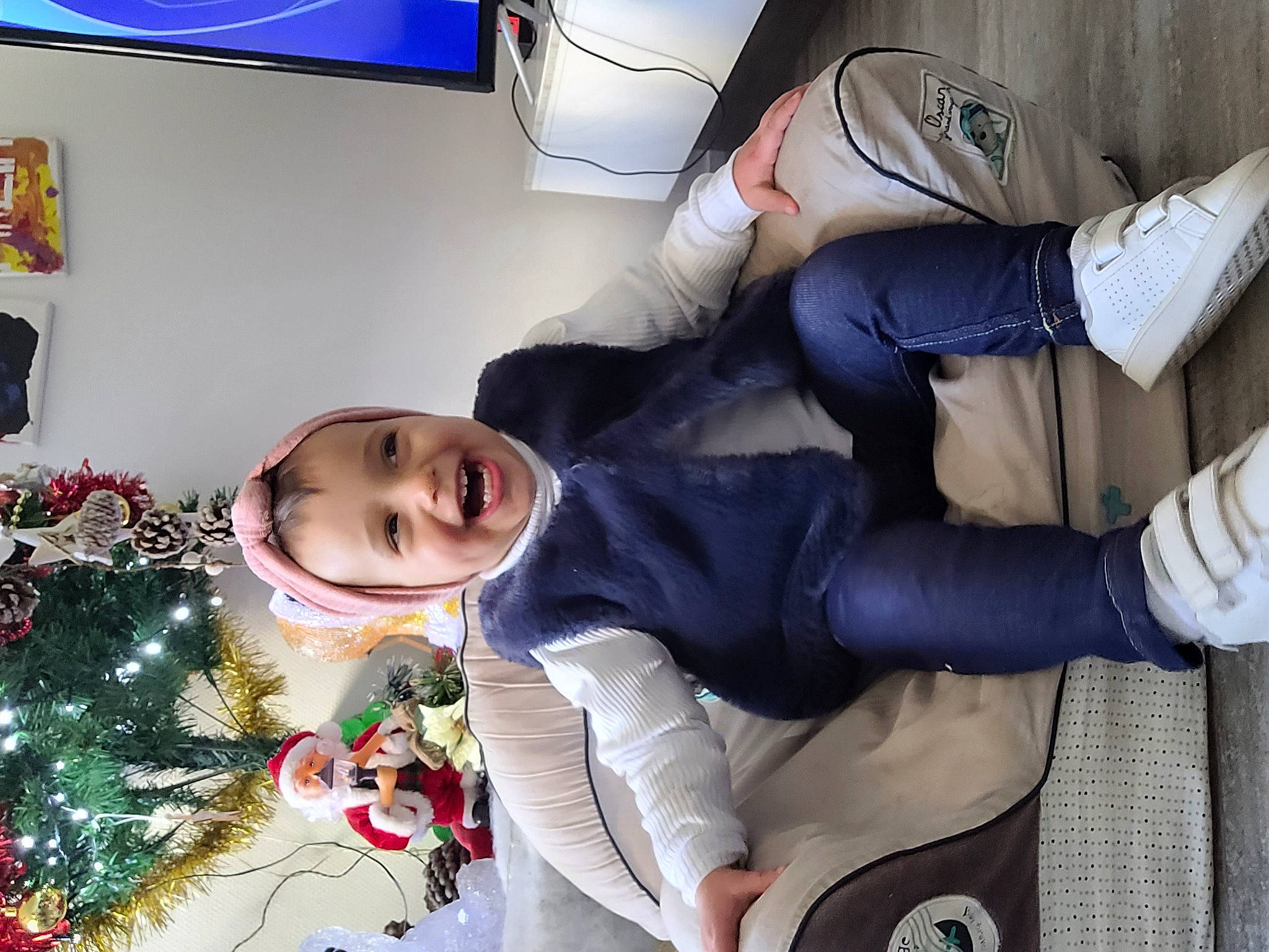 Malia participe au concours pour gagner de l'argent avec cette photo : child, christmas_decoration, christmas_ornament, christmas_tree, comfort, conifer, event, fictional_character, fir, fun, happy, holiday, holiday_ornament, joy, lap, ornament, person, room, sitting, toddler