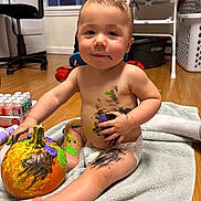 Elliott joined the competition — help win amazing prizes! baby, child, toddler, portrait, sitting, smiling, indoor, pumpkin, painting, paint, art_supplies, creative, messy, diaper, barefoot, towel, laundry_room, basket, window, playful