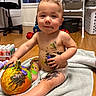 baby, child, toddler, portrait, sitting, smiling, indoor, pumpkin, painting, paint, art_supplies, creative, messy, diaper, barefoot, towel, laundry_room, basket, window, playful