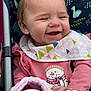 baby, smiling, stroller, bib, pink_clothing, blanket, snowman_print, child, happy, cute, infant, outdoor, dinosaur_pattern, seat, person, portrait, warm_clothing, hands, face, head