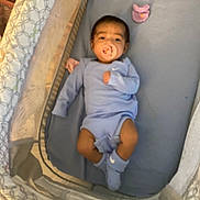 Ezra is registered to the contest to win money with this photo: baby, infant, pacifier, onesie, socks, playpen, mattress, blanket, sleepwear, indoor, resting, child, person, blue, pink, soft, baby_care, cute, baby_girl, baby_boy