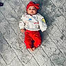 Ezra is registered to the contest to win money with this photo: baby, infant, child, portrait, lying_down, red_bow, red_clothing, hello_kitty, blanket, gray_blanket, indoor, closeup, face, wide_eyed, neutral_expression, barefoot, sweatshirt, pants, cute, cozy