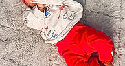 Ezra joined the competition — help win amazing prizes! baby, child, infant, portrait, lying_down, smiling, red_headband, red_clothing, white_shirt, plush_toy, stuffed_animal, blanket, furry_blanket, indoor, fashion, casual_clothing, hand, feet, toy, photography