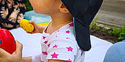 Arya participe au concours pour gagner de l'argent avec cette photo : backwards_cap, cap, casual, child, daylight, grass, hat, outdoor, patterned_clothing, people, picnic, pink_stars, polka_dots, red_toy, side_profile, sitting, toddler, toy, white_blanket, yellow_toy