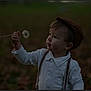 toddler, child, boy, cap, white_shirt, suspenders, dandelion, hand, outdoor, nature, curious, portrait, grass, plant, fall, leaves, interaction, person, young_child, soft_light
