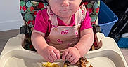 Eden is registered to the contest to win money with this photo: toddler, child, highchair, food, scrambled_eggs, pancakes, toddler_clothing, pink_shirt, face, hands, eating, meal, indoor, plastic_tray, curious_expression, hair, baby, kitchen, home, table