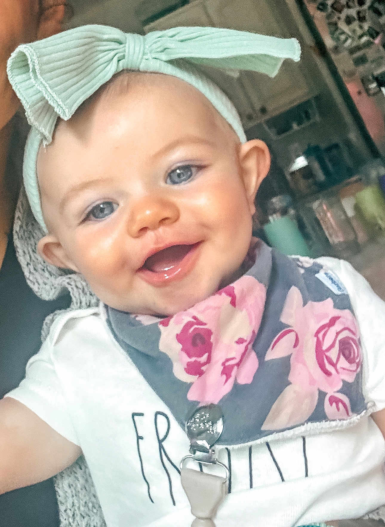 Kamryn is registered to the contest to win money with this photo: baby, child, smiling, headband, bow, blue_eyes, bib, floral, indoor, closeup, cute, happy, infant, person, toddler, clothing, portrait, face, skin, young_child