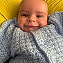 baby, smile, face, knitted_sweater, blue, yellow_cushion, cozy, child, infant, portrait, happy, button, closeup, cute, warm, indoor, person, head, skin, expression