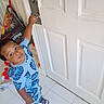 Messiah is registered to the contest to win money with this photo: child, toddler, door, doorknob, blue_clothing, leaf_pattern, indoor, tile_floor, footwear, bag, toy, curious, looking_up, person, standing, hand, home, casual, young_child, playful