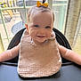 Emelia is registered to the contest to win money with this photo: arm, baby, bib, child, clothing, curtain, cute, face, hair, happy, high_chair, indoor, infant, person, portrait, smiling, sunlight, table, window, yellow_bow