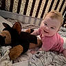 Josie is registered to the contest to win money with this photo: baby, child, infant, smiling, happy, portrait, crib, bedroom, plush_toy, stuffed_animal, dog_toy, blanket, bedding, pink_shirt, sitting, crawling, indoor, nursery, cozy, photography
