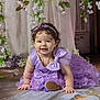 baby, child, dress, purple, bow, flower, crawling, smile, headband, portrait, cute, indoor, decor, curly_hair, jewelry, person, happy, toddler, soft_lighting, floor
