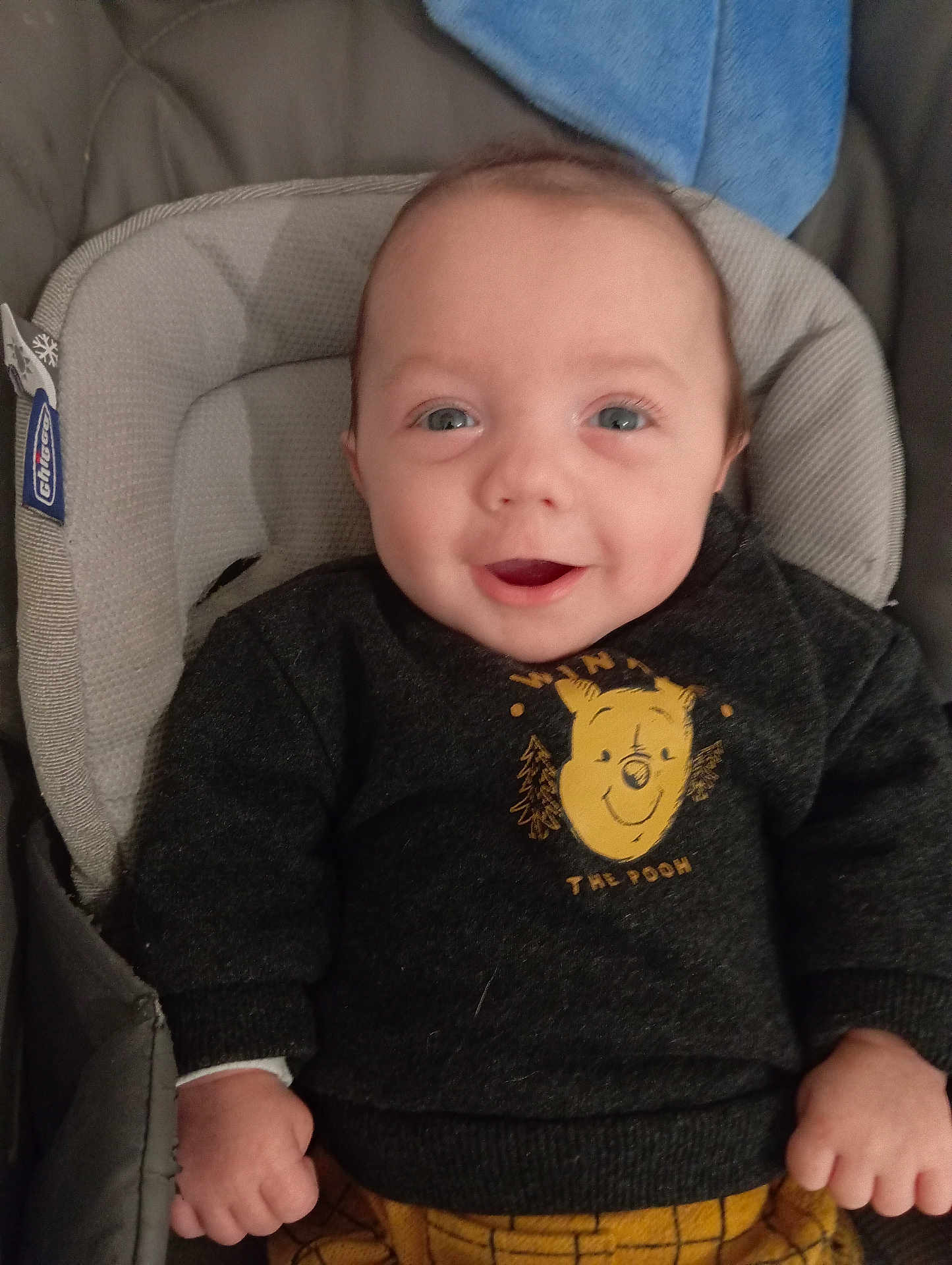 Tyler a rejoint le concours — aidez-le/la à gagner de superbes lots ! baby, infant, smiling, face, sweater, winnie_the_pooh, clothing, child, seat, baby_chair, blue_towel, hand, cute, portrait, indoors, young_child, happy, person, cozy, warm_clothing