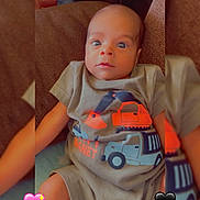 Sevyn is registered to the contest to win money with this photo: baby, child, infant, cute, shirt, construction_vehicle, sitting, couch, indoors, face, eyes, expression, person, clothing, heart_emoji, brown, soft, cute_outfit, portrait, young